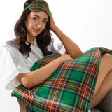 A woman white robe is sitting on a chair, holding tartan green silk pillowcase and silk eyemask